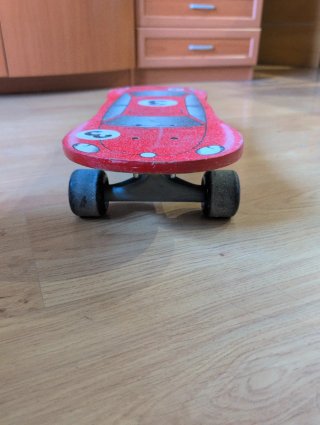 Monopatín Oxelo rojo con diseño de coche.