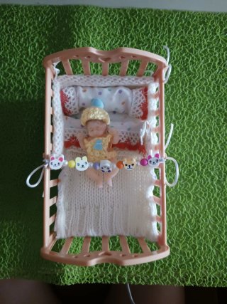 Cuna de juguete con bebé y accesorios