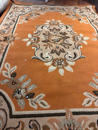 Alfombra naranja y marrón con diseño floral
