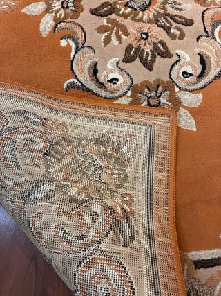 Alfombra naranja y marrón con diseño floral