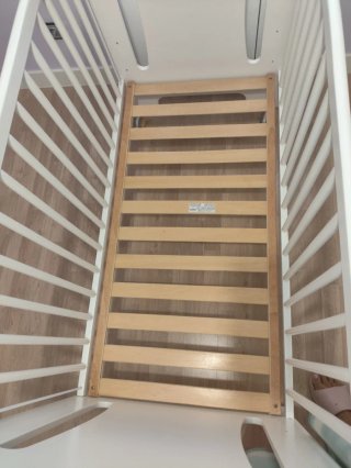 Cuna de madera blanca con letras de colores.