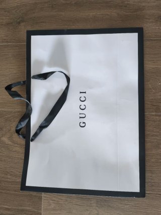 Bolsa de compras Gucci blanca y negra.