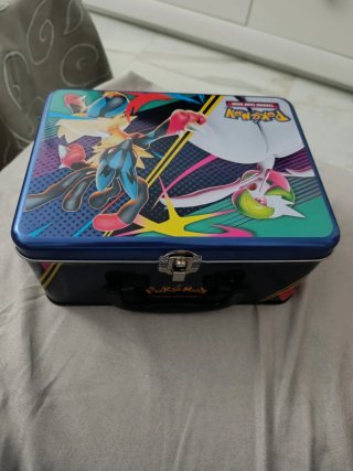 Caja metálica Pokémon con cartas y moneda