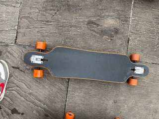 Longboard patinete con ruedas naranjas