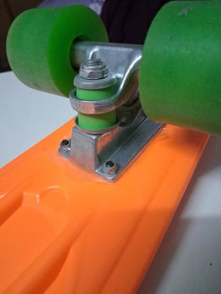 Monopatín naranja con ruedas verdes