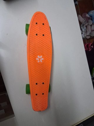 Monopatín naranja con ruedas verdes