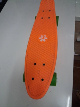 Monopatín naranja con ruedas verdes