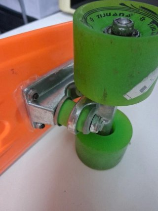 Monopatín naranja con ruedas verdes