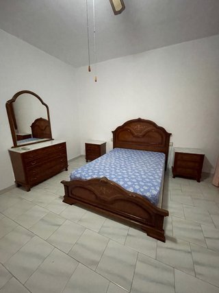 Dormitorio clásico: cama, mesitas, cómoda y espejo