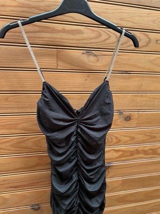 Vestido negro ajustado con tirantes.