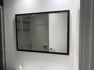 Espejo de baño con marco de madera.