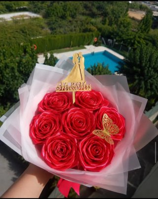 Ramo de rosas rojas con mariposa dorada