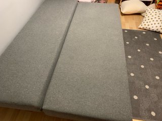 Divano letto grigio a 3 posti con due cuscini