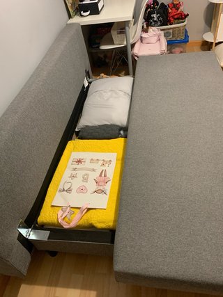Divano letto grigio a 3 posti con due cuscini