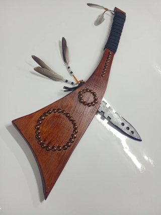 Hacha decorativa con plumas y abalorios