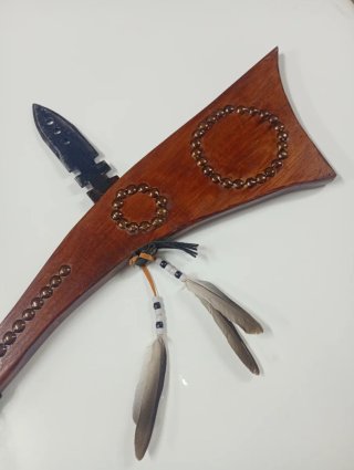 Hacha decorativa con plumas y abalorios