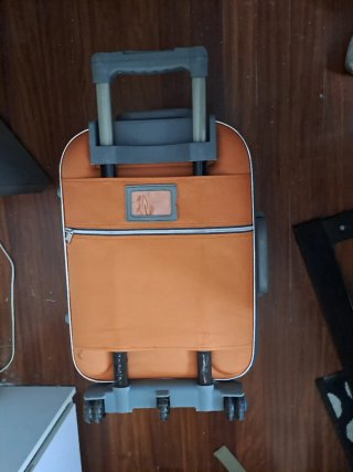 Maleta de viaje naranja y gris con ruedas