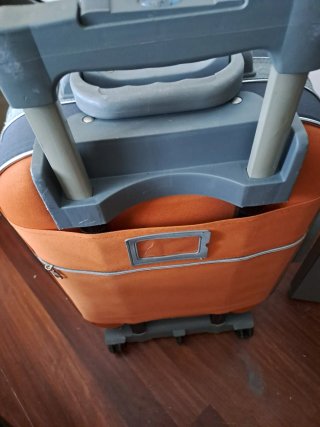 Maleta de viaje naranja y gris con ruedas