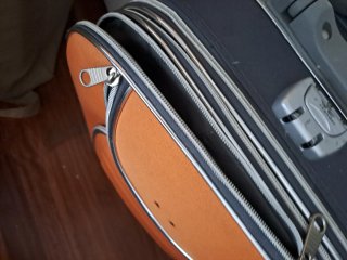 Maleta de viaje naranja y gris con ruedas