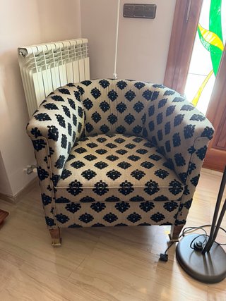 Sillón tapizado con bordados en relieve.