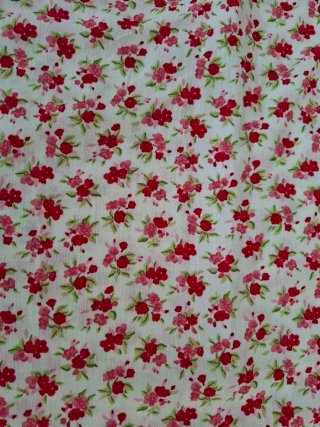 Vestido Pimkie flores rosas y rojas y fondo beige.
