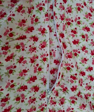 Vestido Pimkie flores rosas y rojas y fondo beige.