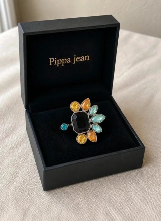 Anillo de cóctel negro con cristales multicolor.