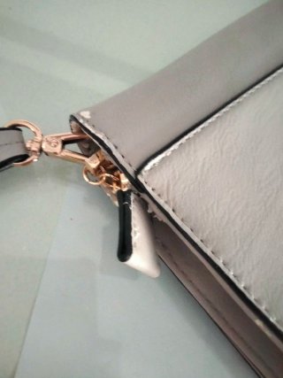 Bolso de mano beige con tachuelas doradas