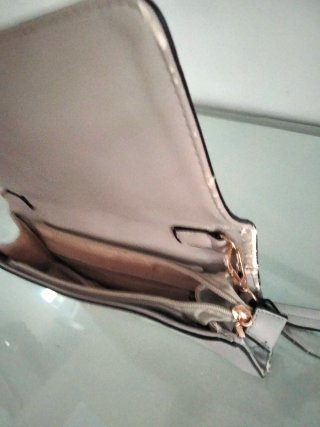Bolso de mano beige con tachuelas doradas