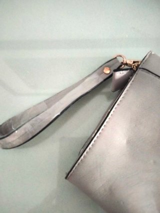 Bolso de mano beige con tachuelas doradas