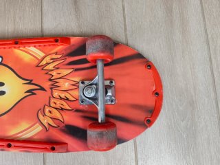 Monopatín con diseño de fuego y cara sonriente