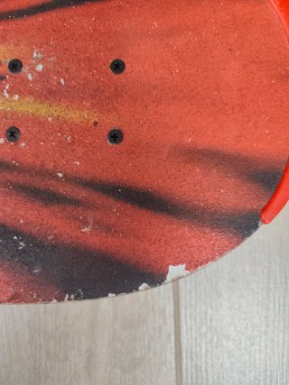 Monopatín con diseño de fuego y cara sonriente