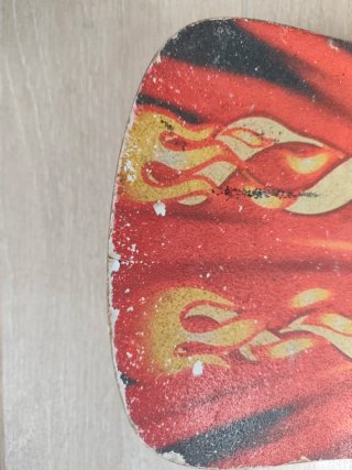 Monopatín con diseño de fuego y cara sonriente