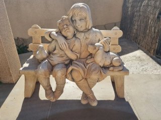 Figura de jardín de piedra con niños y animales