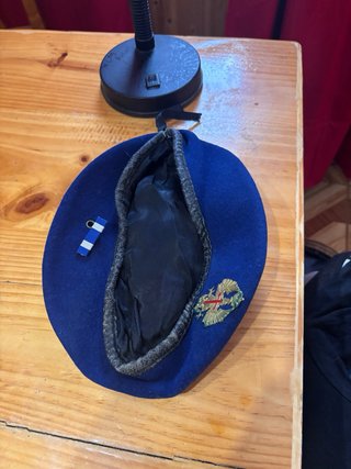 Boina militar azul con insignia dorada