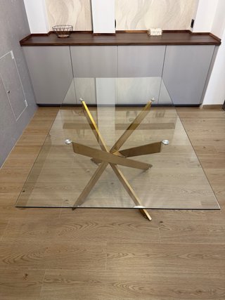 Mesa de comedor cristal y patas doradas.