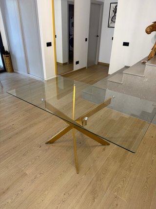 Mesa de comedor cristal y patas doradas.