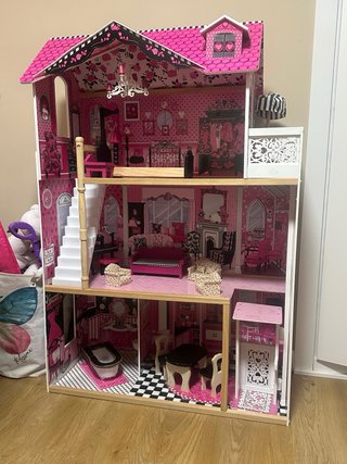Casa de muñecas rosa con muebles