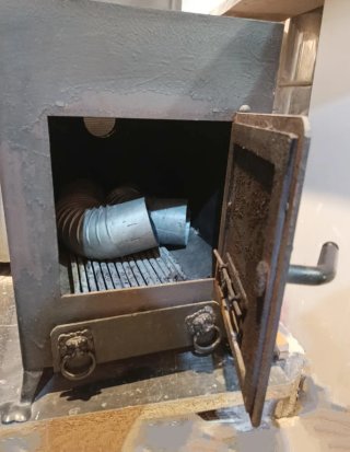 Estufa de leña con horno metálica negra.