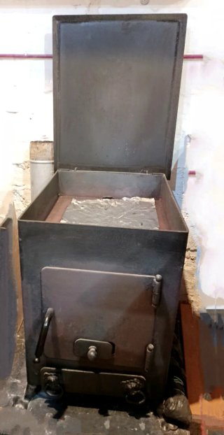 Estufa de leña con horno metálica negra.