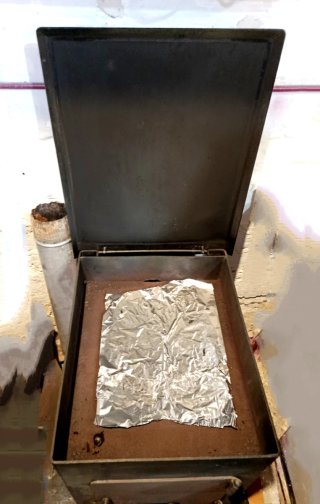 Estufa de leña con horno metálica negra.