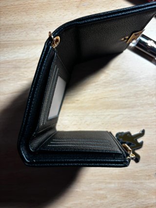 Cartera negra con pulsera de perlas