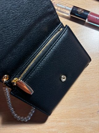 Cartera negra con pulsera de perlas