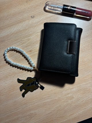 Cartera negra con pulsera de perlas