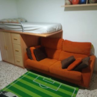 Habitación juvenil: Cama alta, sofá y armario