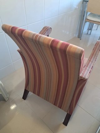 Butaca de tela con patas de madera lacada en grana