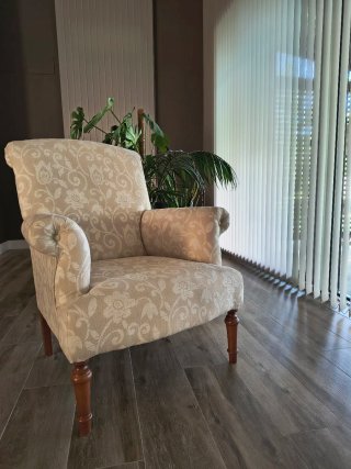 Butaca de tela beige con patas de madera