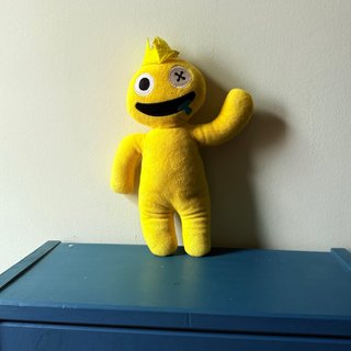 Peluche amarillo con boca y ojo