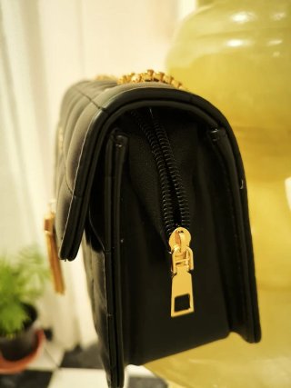 Bolso negro con inicial V y cadena dorada