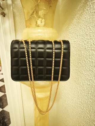 Bolso negro con inicial V y cadena dorada